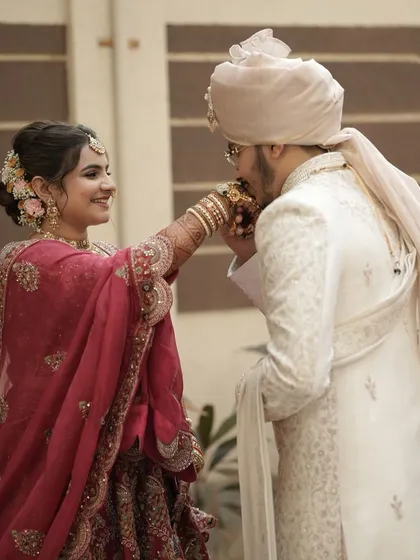 A tender moment between the couple. Her soft makeup and traditional floral bun highlight the romance of the occasion.