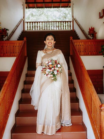 The bride making a grand entrance down a wooden staircase, her flowing veil and bouquet adding to the elegance of the moment.