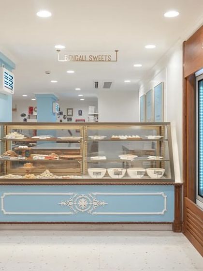 Another view of the main counter area, showing how the open-plan layout encourages flow and exploration. The design balances the retail display with historical elements, creating a space that is both a shop and a gallery of the brand's rich past.