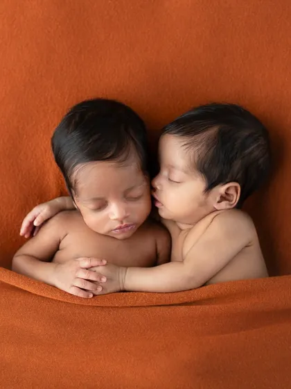 What do you think she's whispering? This adorable portrait of newborn twins invites you to imagine the secret conversations happening between them.
