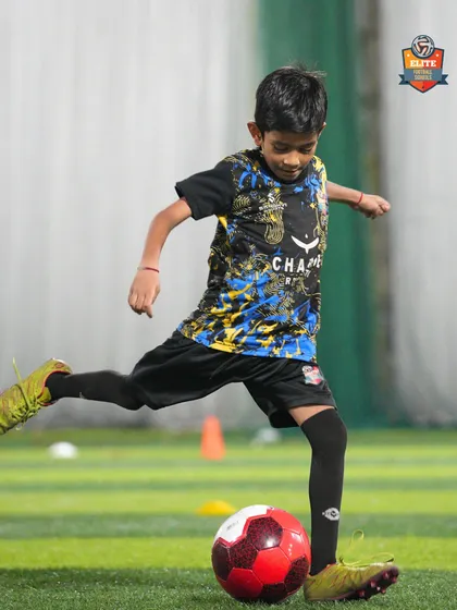 A young player strikes the ball, practicing his shooting technique to build power and accuracy.