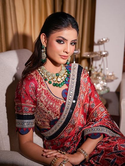 A stunning reception look featuring a soft glam makeup style. The eyes are defined with warm, earthy tones, and the skin is kept luminous to complement this printed Nitya Bajaj saree.