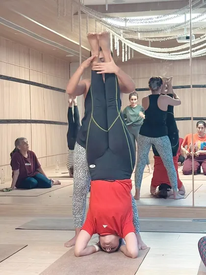 A workshop is a space of shared energy and strength. In this photo, I'm guiding a student into a stable headstand, while others in the group practice at their own pace. It’s about creating a supportive environment where everyone can find their power.
