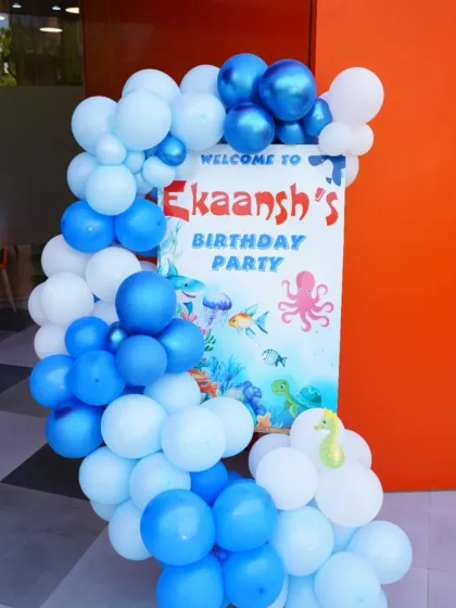 An 'Under the Sea' themed welcome sign for Ekaansh's birthday. The blue balloons and ocean creature graphics create a cool, aquatic vibe.