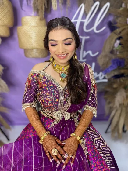 A dewy glam look for Khushbu's Mehendi. The purple tones in her makeup perfectly match her vibrant outfit, creating a fun and festive look.