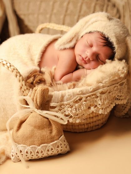 A detailed shot of the boho bunny theme, showing the baby nestled in a basket with a burlap sack prop, all in warm, neutral tones for a cohesive and aesthetic look.
