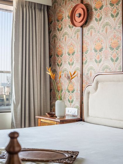 Spread across 1200-square feet, this residential space exudes tranquility with traditional details woven in seamlessly. The home is adorned with minimal details and a color palette of white, beige, grey and sage green. Natural materials such as wood, stone, and cane are used to add texture, while wallpapers with tropical imagery and traditional motifs add visual interest to the spaces.