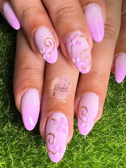 A surreal pink ombre design. This look features a soft gradient, 3D sculpted flowers, and delicate gold swirl accents for a dreamy and feminine style.