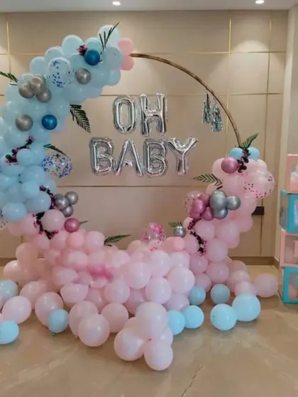 A dreamy "Oh Baby" setup with a crescent moon balloon arch. The mix of pastel pink and blue balloons with silver accents creates a soft and magical atmosphere for a baby shower or gender reveal.