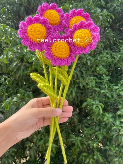 A bouquet of vibrant magenta stuffed daisies, a bold and beautiful color.