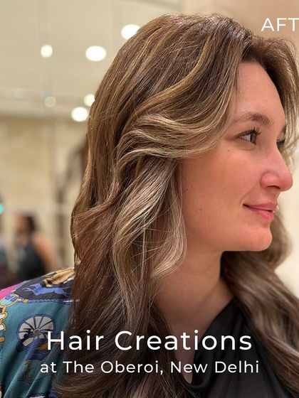 A profile view of the cool ash colour, showing how the curtain bangs and waves frame the face and highlight the custom tones.