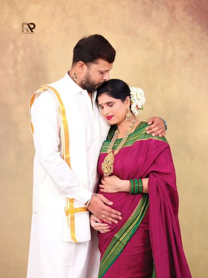 A portrait filled with tenderness and affection. The husband gently holds his wife, both dressed in beautiful traditional clothing, creating a classic and heartfelt image.