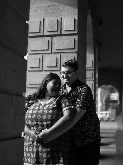 A dramatic black and white photo using shadows and light within an architectural corridor to create a timeless and artistic couple portrait.