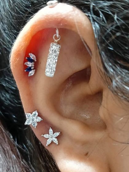 A cool-toned stack with a vertical bar hanging, blue and white floral studs, creating a unique color story.