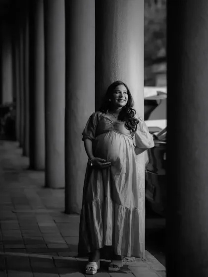 Black and white photography strips away all distractions, leaving only emotion and form. Anisha stands among the pillars, the natural light creating a timeless, classic portrait that feels both strong and graceful.