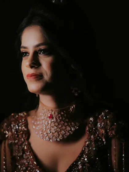 A dramatic solo portrait of the bride. The focused lighting and dark background make her stand out, creating a powerful and elegant image.