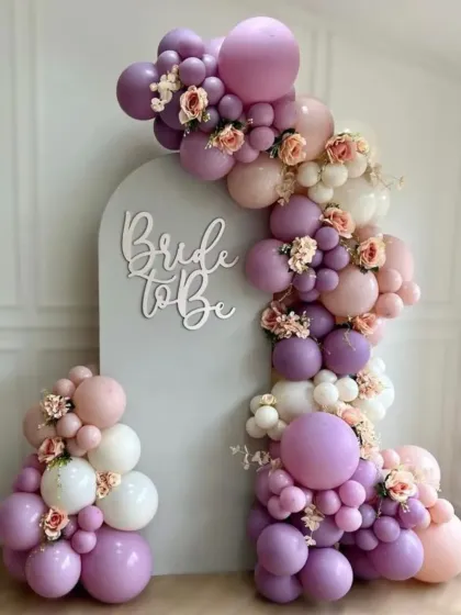 A beautiful "Bride to Be" setup with a lovely color palette. The lilac, pink, and white balloons are accented with small artificial flowers for a soft and romantic feel.