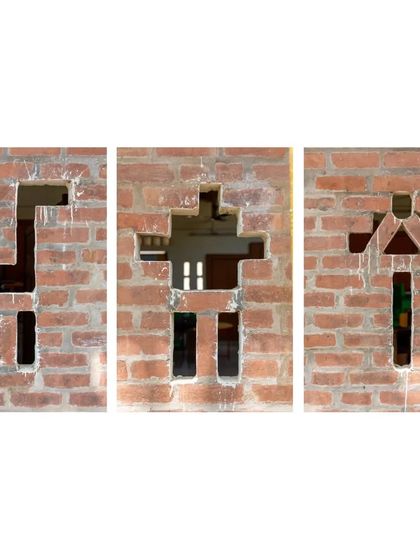 Playful openings in the brick wall of the Spastic Society classroom. These shapes, resembling animals and people, were created by strategically leaving out bricks, a simple yet creative way to add character and ventilation using a basic material.