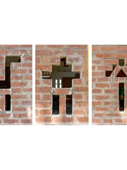 Playful openings in the brick wall of the Spastic Society classroom. These shapes, resembling animals and people, were created by strategically leaving out bricks, a simple yet creative way to add character and ventilation using a basic material.