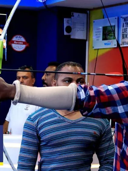 Find your focus and let the arrow fly. An archer takes aim, demonstrating the concentration and form that we teach in our personalized training sessions.