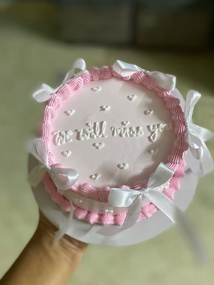 A hand-held shot of the "We will miss you" cake, a beautiful way to say goodbye.