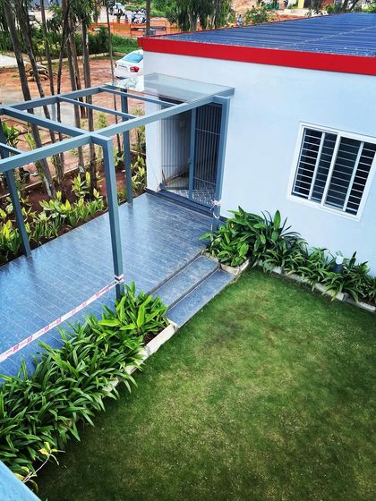 An aerial view of a simple yet elegant landscape solution, with a green lawn and a granite-paved path leading to a pergola. This demonstrates our attention to detail in creating clean, functional outdoor spaces.