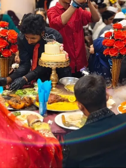 A close-up of the bride and groom's table, adorned with floral arrangements, a tiered cake, and our spectacular food presentation.