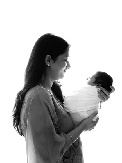A mother's love, captured in a simple, elegant silhouette. This style of photography creates a timeless and artistic portrait, focusing on the bond you share with your new baby.