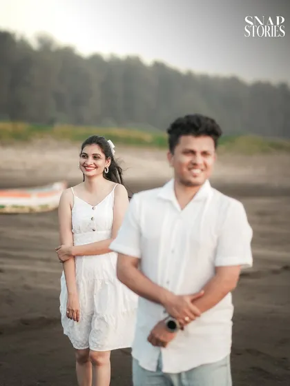 A creative shot using depth of field to focus on the bride-to-be while the groom is softly blurred in the foreground, adding an artistic touch to the pre-wedding photo.