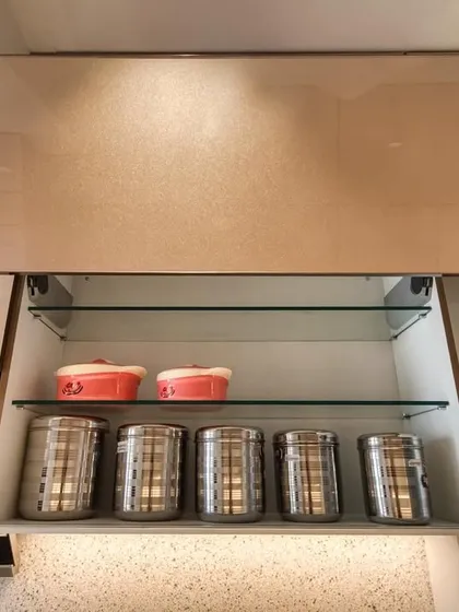 A bi-fold lift-up cabinet with glass shelves, perfect for storing everyday crockery and glassware.