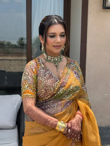 The client looks serene and elegant with her braided ponytail. The hairstyle complements her heavily embroidered saree without competing with it.