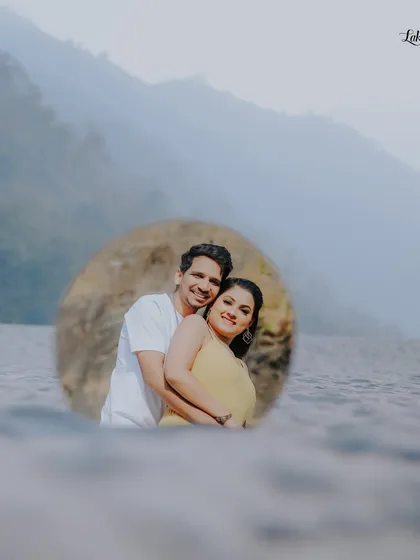A creative shot using a circular frame to highlight the couple against the beautiful backdrop of the water and hills in Rishikesh.