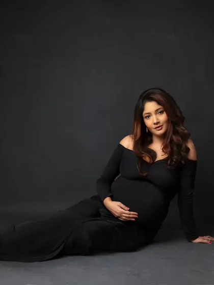 A relaxed, floor-seated pose in a classic black off-shoulder gown. This is a comfortable yet incredibly chic look.