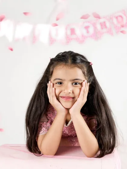 A sweet and simple portrait of the birthday girl. Her genuine smile and the soft pink background make this a timeless photo from her fifth birthday shoot.