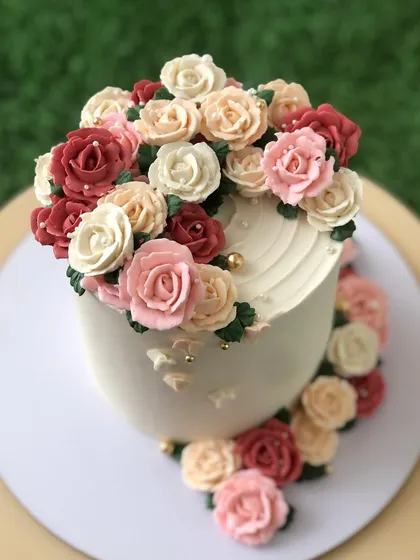 This cake is a celebration of my favorite medium: buttercream. I piped this cascade of multi-toned roses by hand, creating a floral masterpiece that's as delicious as it is beautiful.