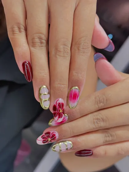 An elegant and artistic design combining deep red with a pink ombre. The look is elevated with 3D gold chrome accents and intricate floral details.
