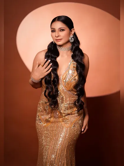 A three-quarter shot that captures the texture of the gown and the sparkle of the jewelry. The pose is soft and elegant, adding a touch of grace to the powerful look.