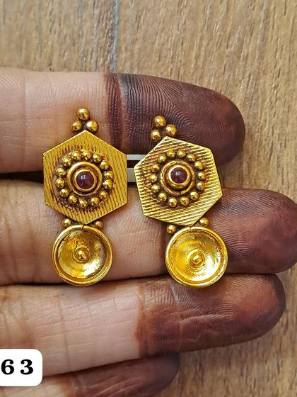 A simple yet elegant pair of antique gold-plated earrings. The hexagonal top is paired with a small golden bowl-shaped drop.