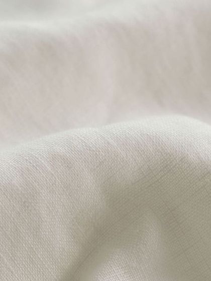 The soft, natural texture of a high-quality white linen fabric, ideal for comfortable and stylish summer shirts.
