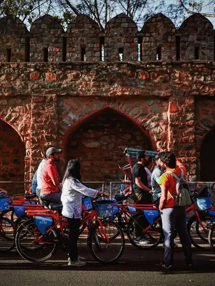 We often pause our ride to gather and share stories against the backdrop of Delhi's ancient walls. It's a history lesson on wheels.