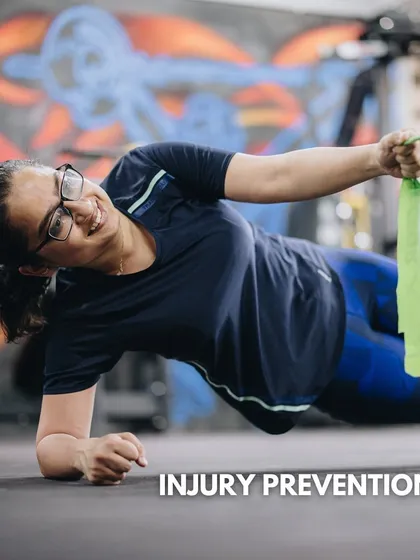 We focus on holistic fitness that goes beyond standard gym routines. This image shows a client working on injury prevention through a side plank with a band row, a movement that builds core stability and shoulder strength simultaneously.