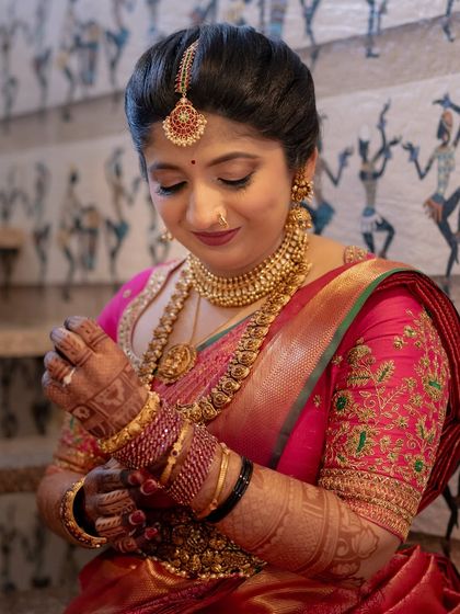 A candid moment of the bride adjusting her bangles, giving a lovely view of her forearm mehendi.