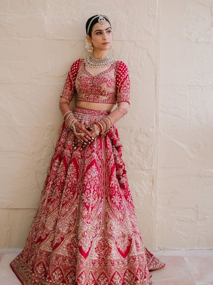 The full bridal look. Varsha looks like a vision in her red lehenga, with makeup that is serene, bright, and absolutely timeless.