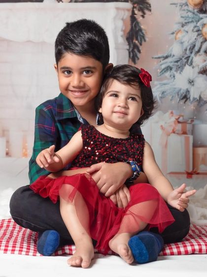 A sweet portrait of a brother and sister enjoying the festive atmosphere of our Christmas-themed studio setup.