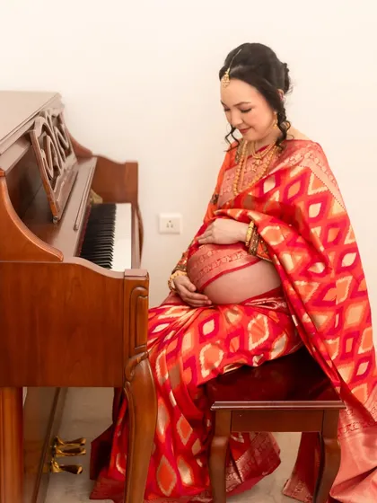 A different angle of the piano portrait, showing the mother connecting with her baby through music, her hands gently cradling her bump.