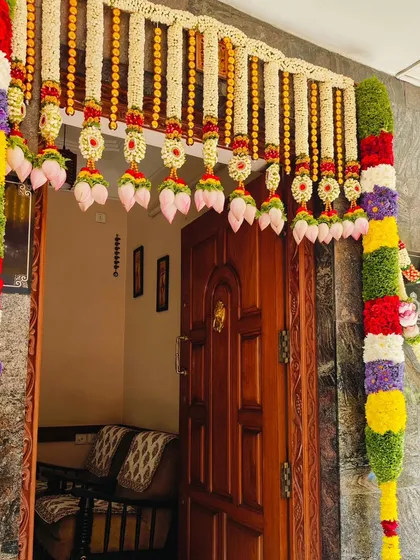 The entrance decoration for a home baby shower. We created a traditional door frame thoran using a variety of colorful flowers and lotus buds to welcome guests.
