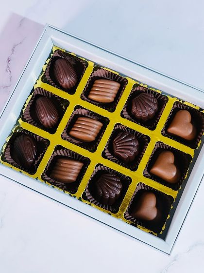 A top-down view of our 12-piece praline collection, showcasing the different shapes and textures of our delicious handmade chocolates.