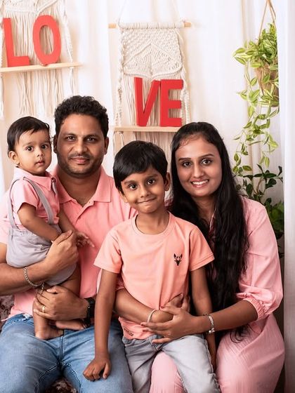 A beautiful family of four in my boho-themed studio. The coordinated outfits and warm smiles make this a perfect family portrait.