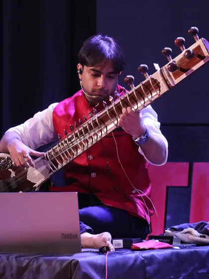 A focused moment during my TEDx talk, using technology to help illustrate the concepts of raag and taal. I blend traditional teaching with modern tools to make learning more effective.
