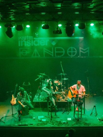 A wide shot of our trio on the Fandom stage, under the green lights. A memorable night of music.
